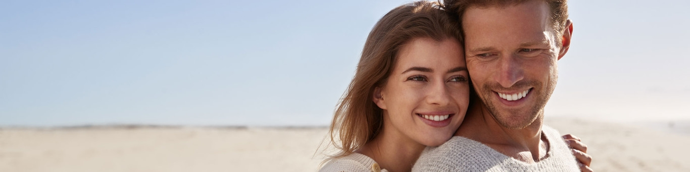 Smiling couple on the beach, happiness and love, sunny day, close-up, happy faces, embrace