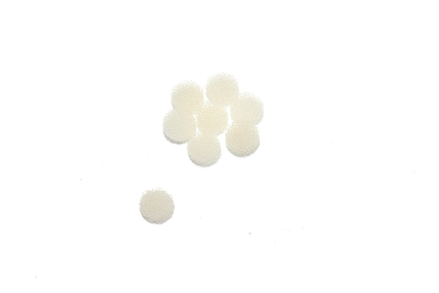 Objets doux, ronds et clairs sur fond blanc, ressemblant à des éponges ou des tampons.